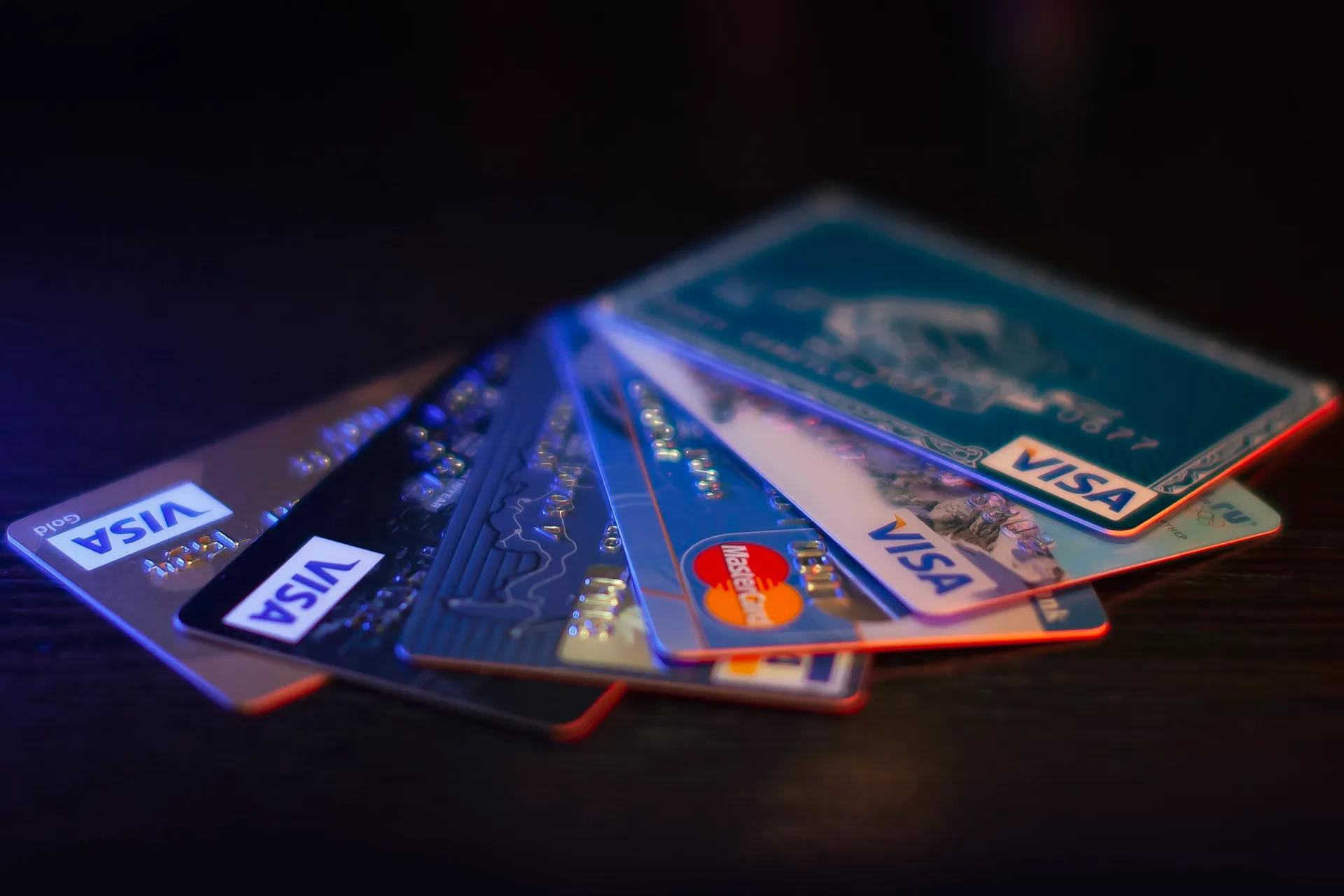 A bunch of credit cards fanned out on a dark surface