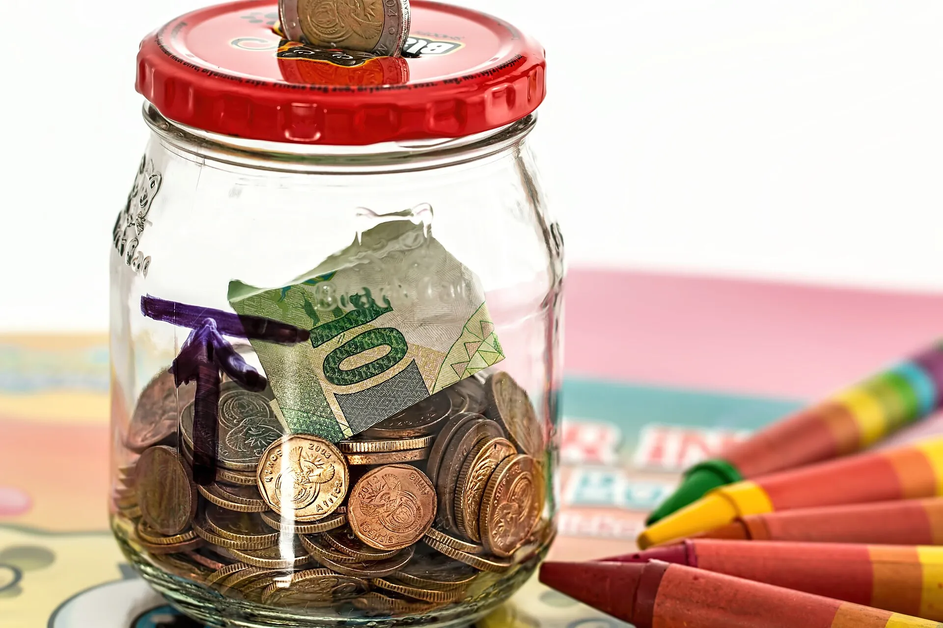 A pink piggy bank filled with coins, symbolizing saving